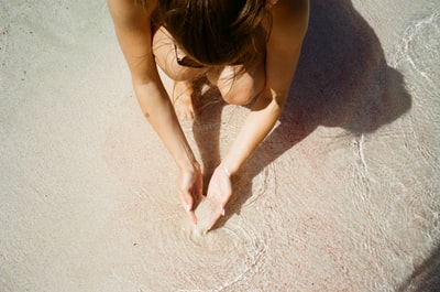 沙滩上拿着沙子的女人